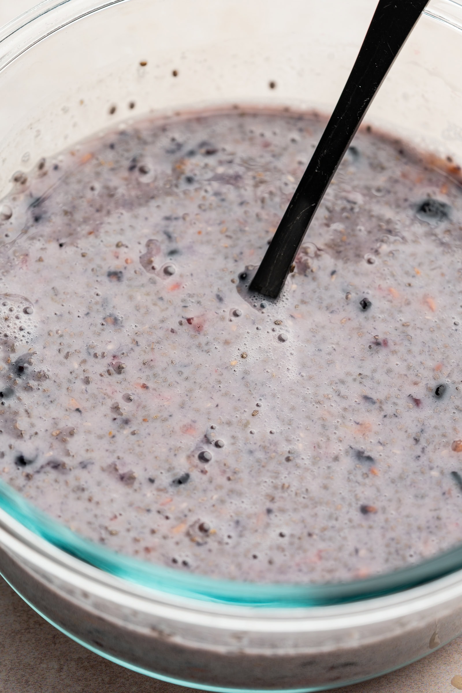 Chia pudding ingredients mixed together in a glass container.