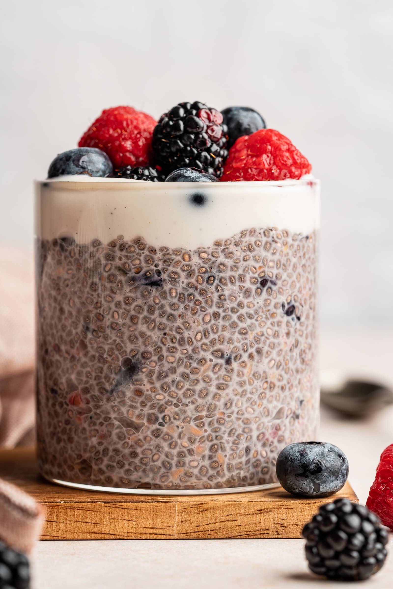 Berry chia pudding in a glass jar and topped with yogurt and fresh berries.