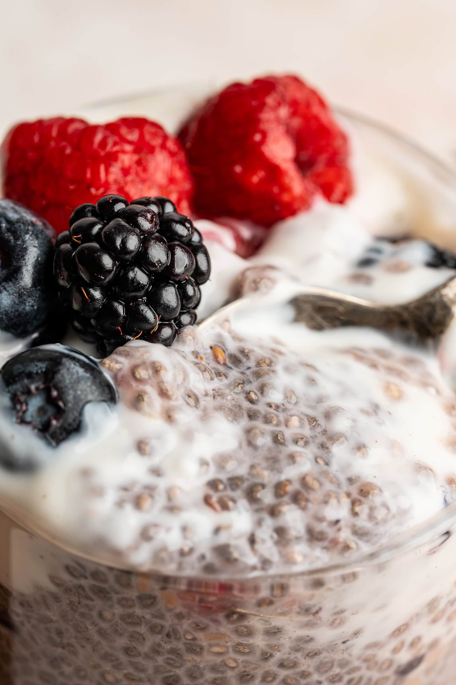Berry chia pudding in a glass jar and topped with yogurt and fresh berries.