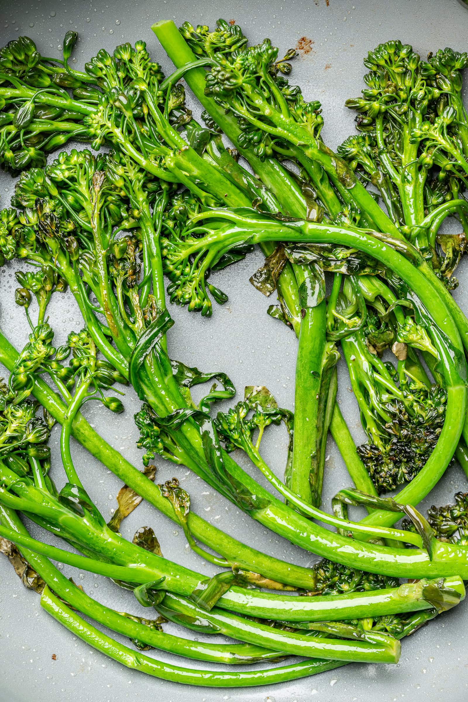Cooked broccolini in a frying pan.