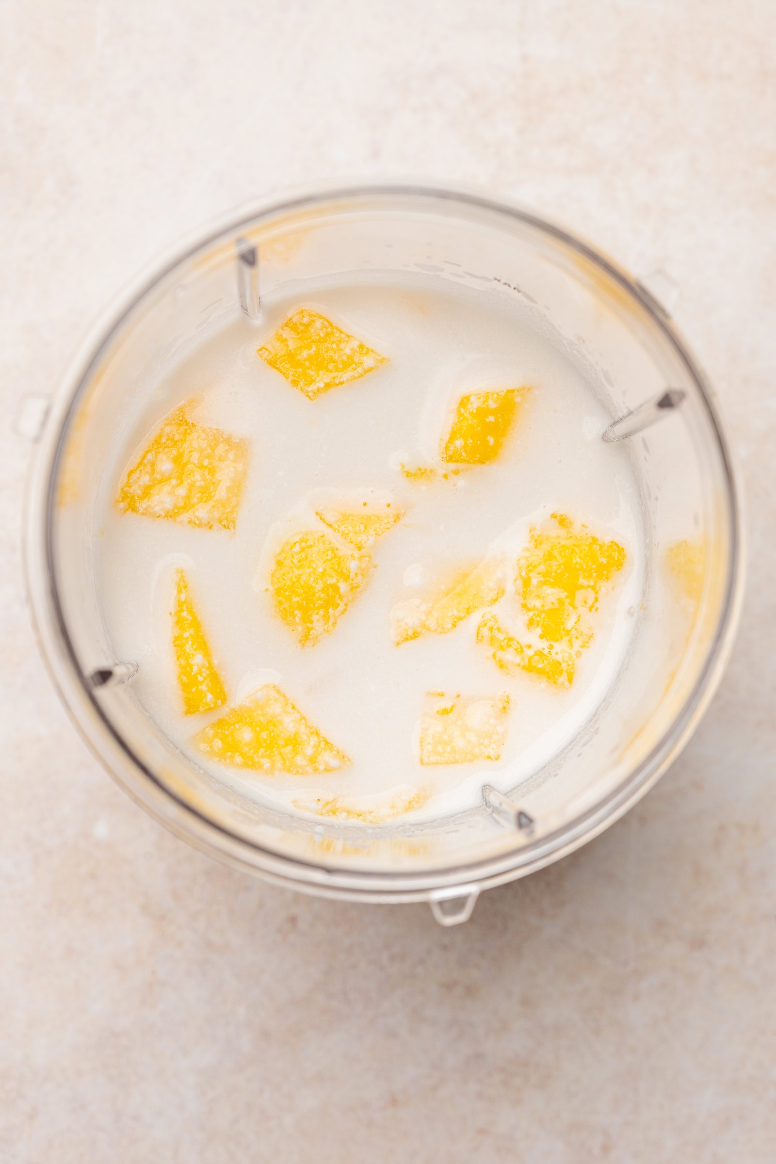 Mango and coconut milk in a blender.