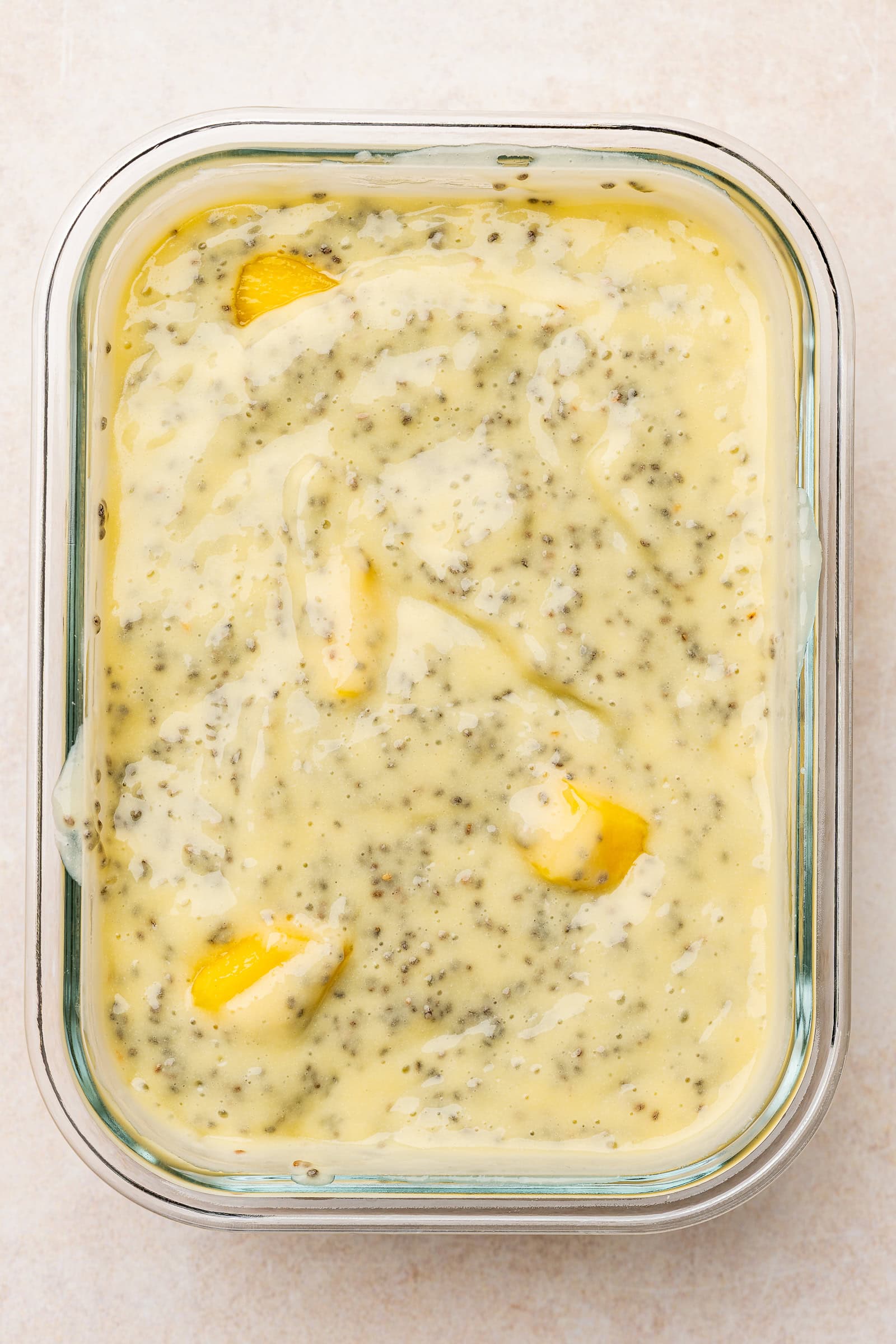 Chunks of mango added to chia pudding mixture.