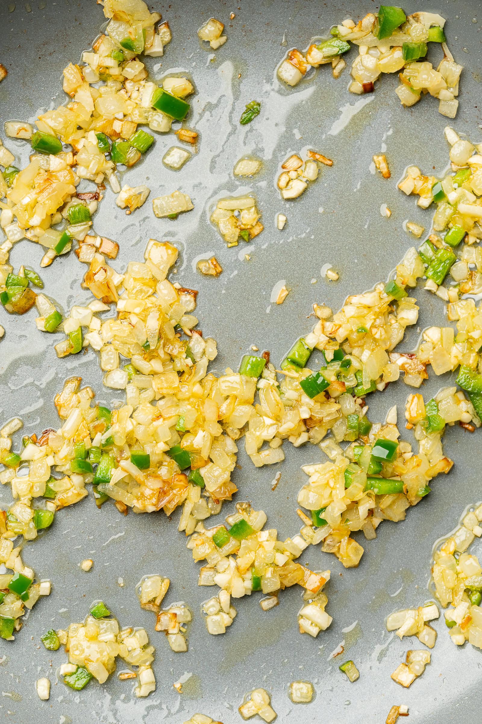 Garlic, onion, and jalapeño in a frying pan.