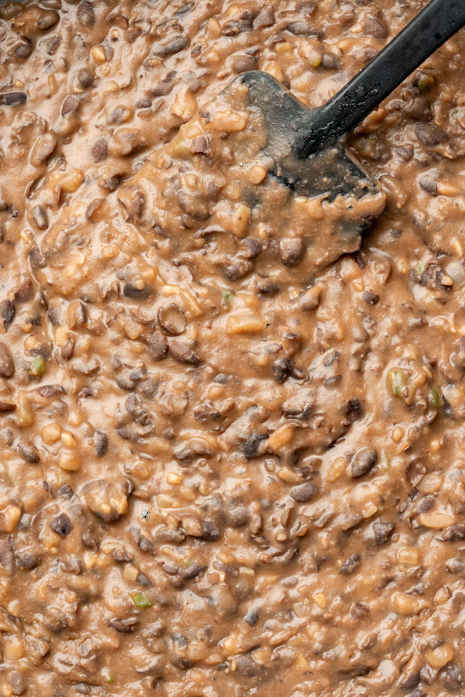 Close up of mashed refried black beans.