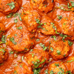 Tofu meatballs in a marinara sauce garnished with basil.