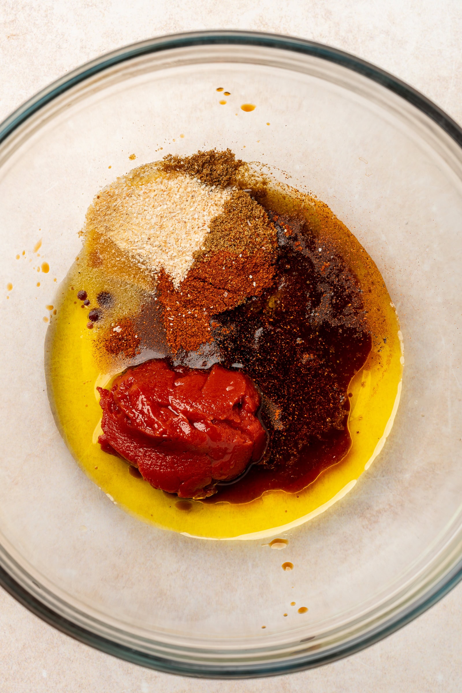 Tomato paste, oil, and spices in a large bowl.