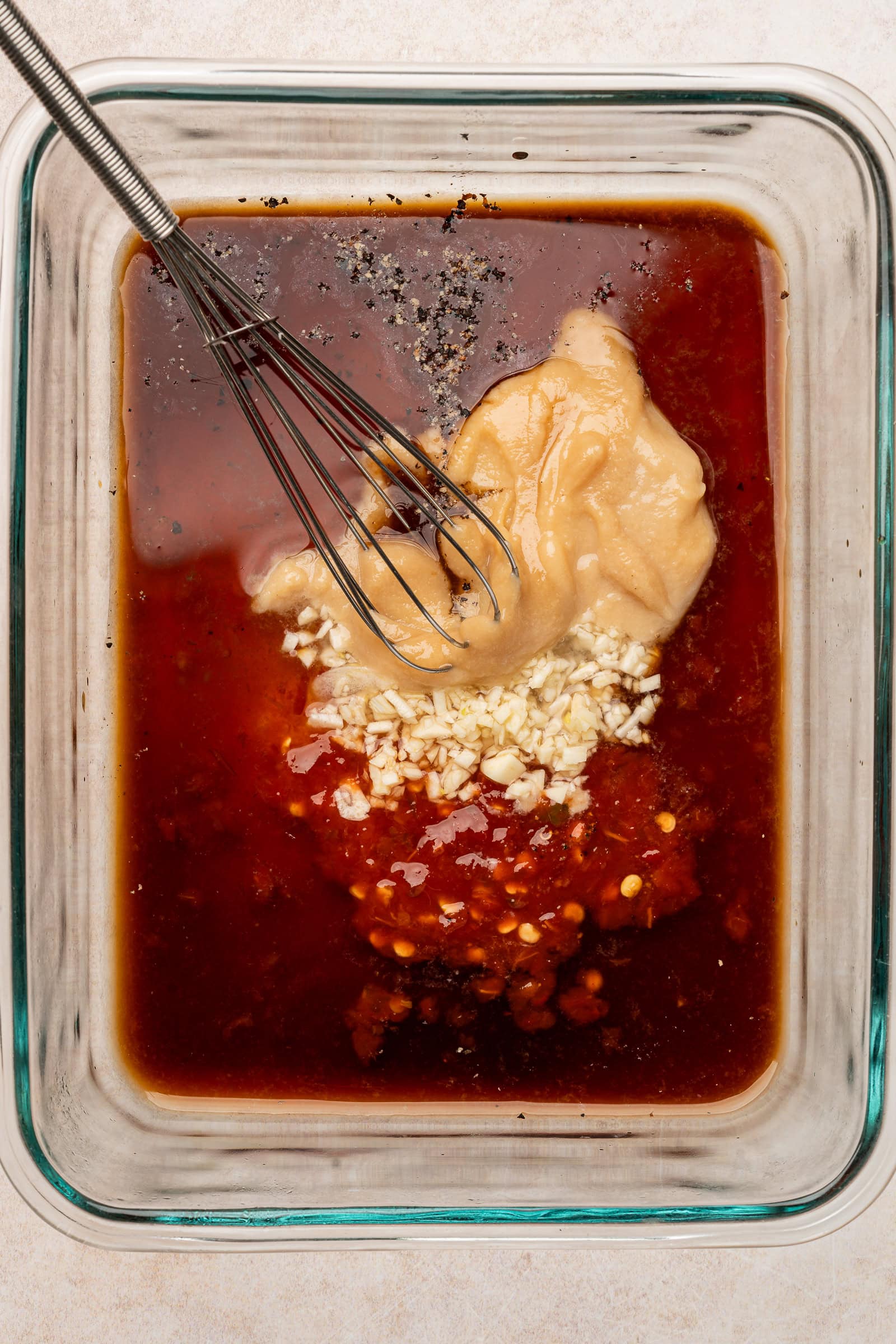 A whisk in a glass bowl.