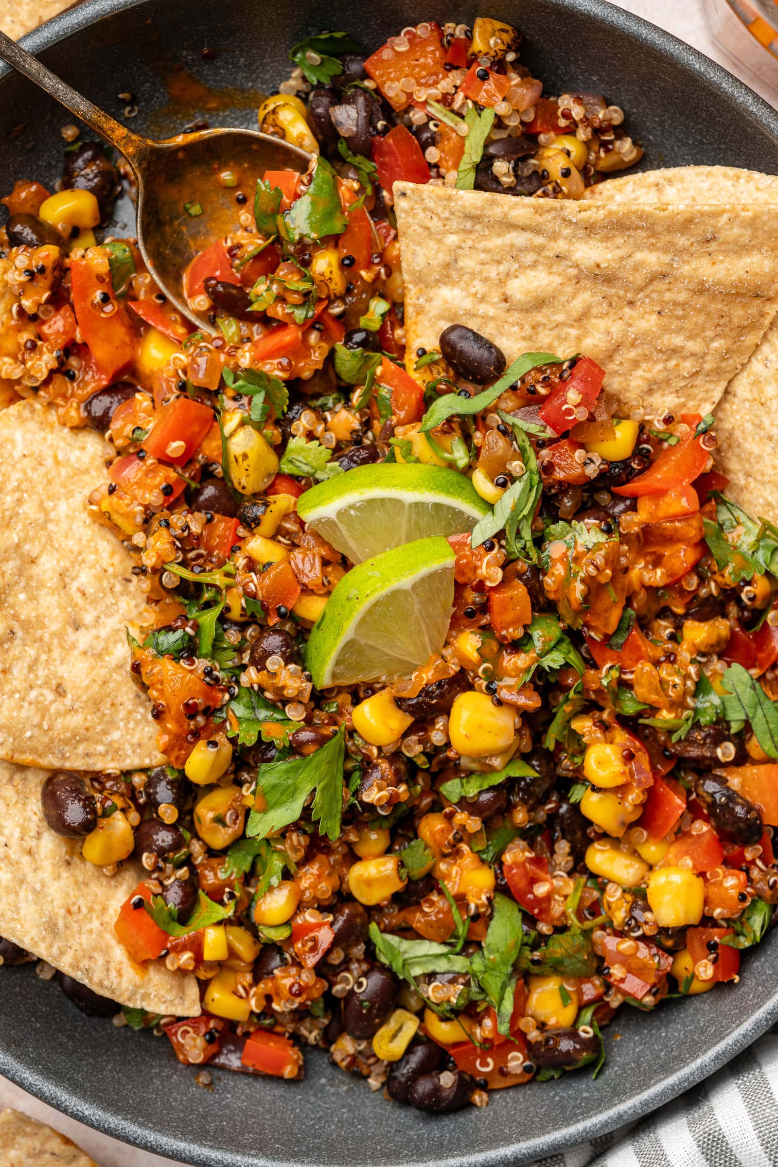 Spicy corn and black bean quinoa salad in a serving bowl with tortilla chips.