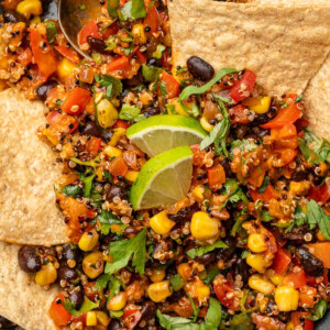 Spicy corn and black bean quinoa salad in a serving bowl with tortilla chips.