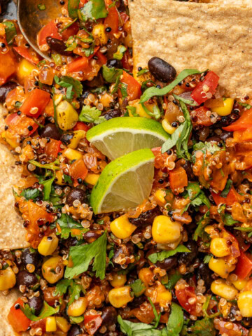 Spicy corn and black bean quinoa salad in a serving bowl with tortilla chips.
