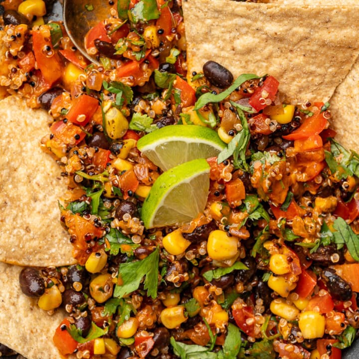 Spicy corn and black bean quinoa salad in a serving bowl with tortilla chips.