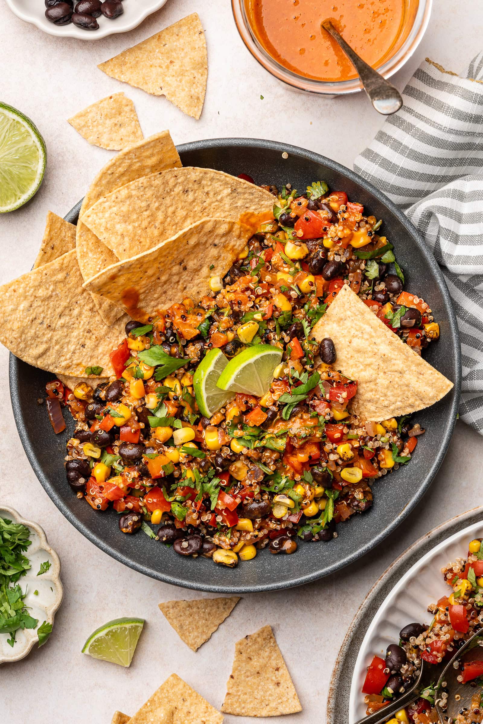 Spicy corn and black bean quinoa salad in a serving bowl with tortilla chips.