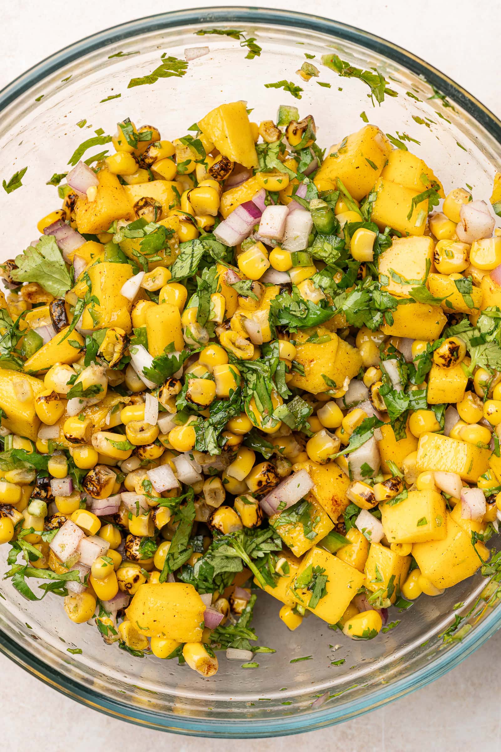 Mango corn salsa being mixed in a large bowl.