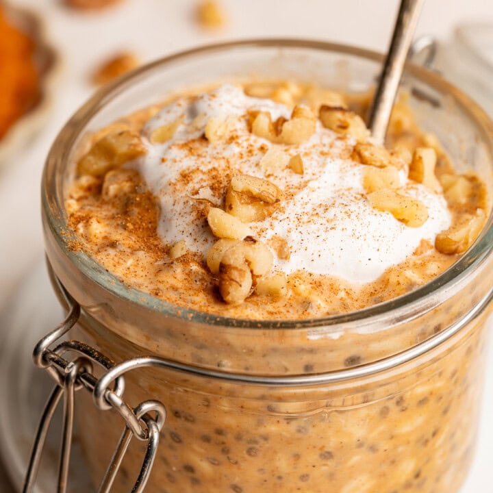 Set overnight oats in a small glass jar topped with coconut whip, walnuts, and a sprinkle of cinnamon.