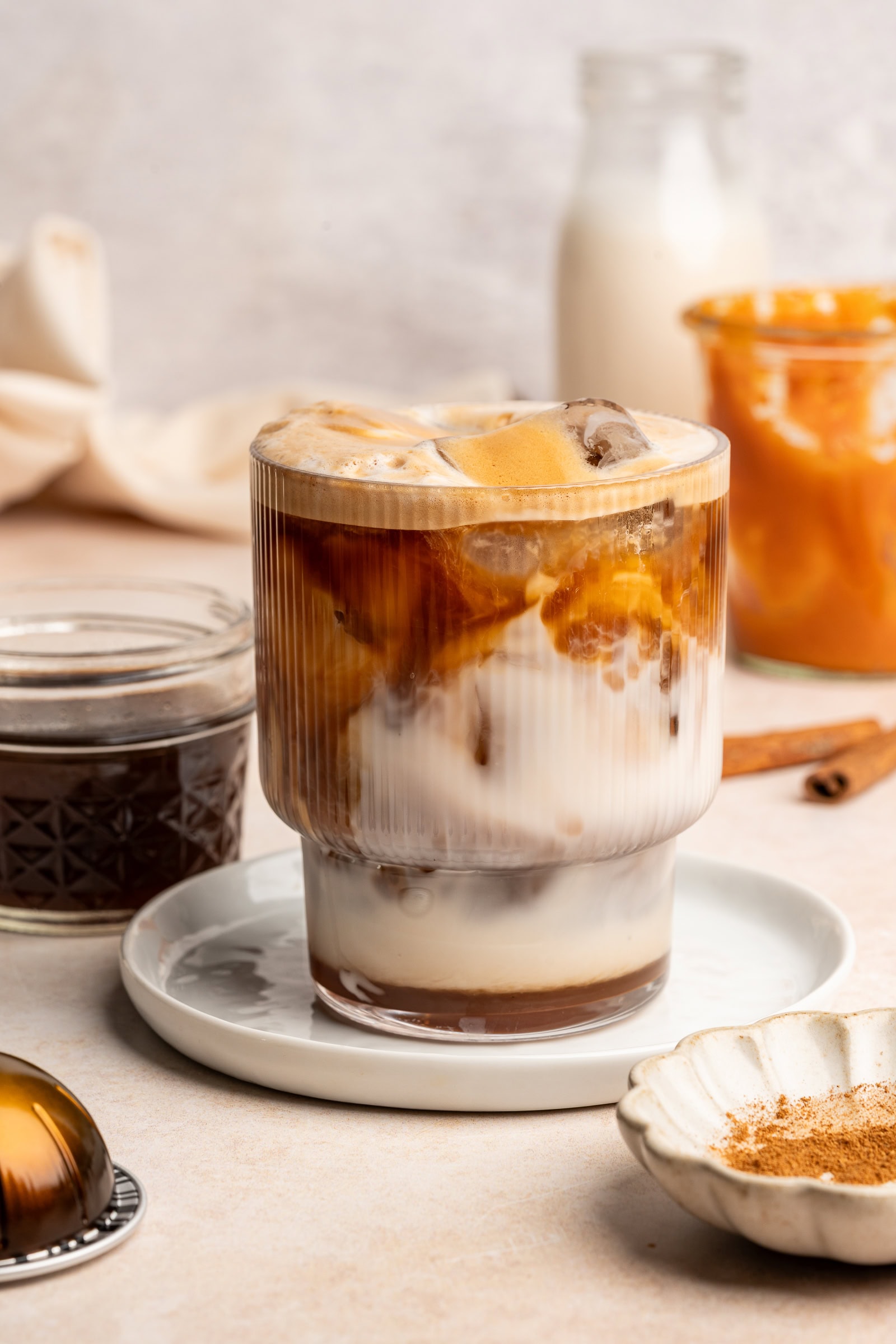 Pumpkin spice latte in a glass cup.