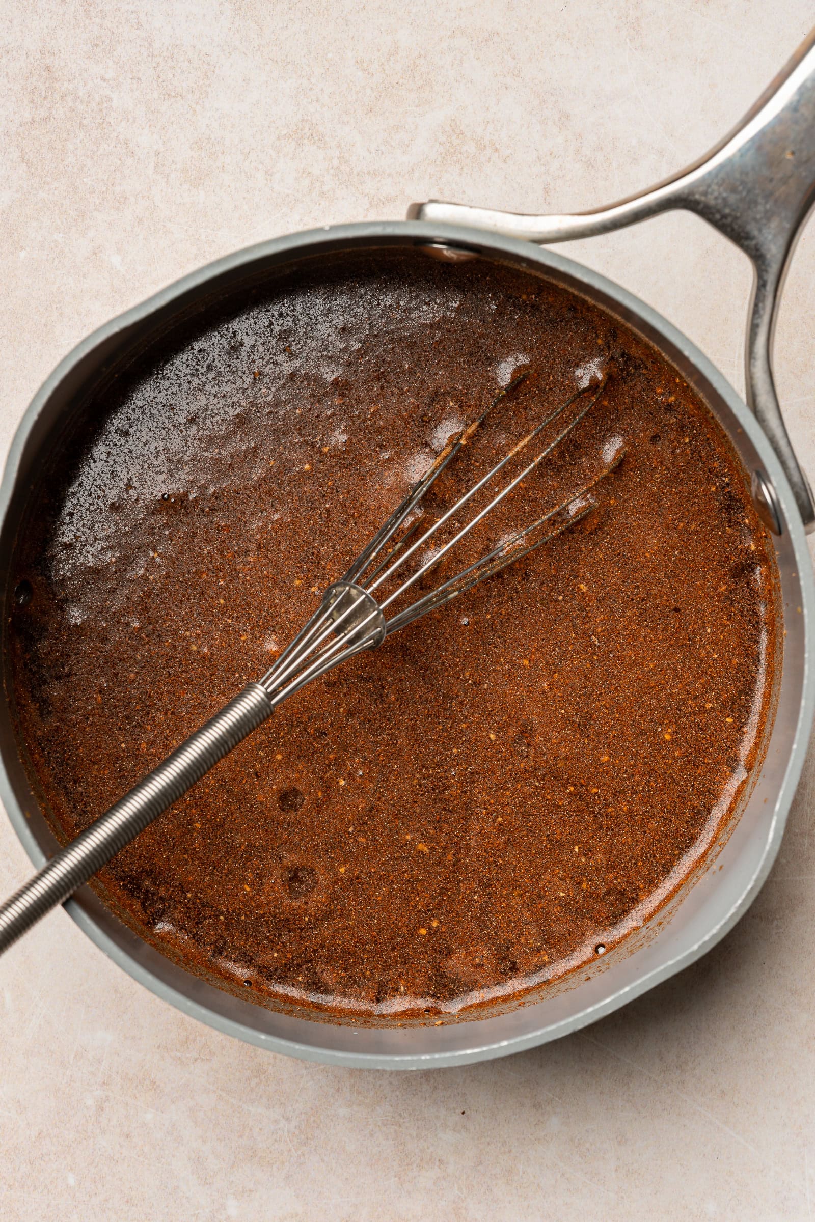 Pumpkin spice syrup being whisked together in a pan.