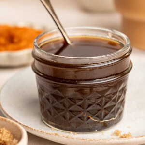 Pumpkin spice syrup in a small jar with a serving spoon.