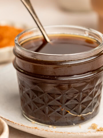 Pumpkin spice syrup in a small jar with a serving spoon.