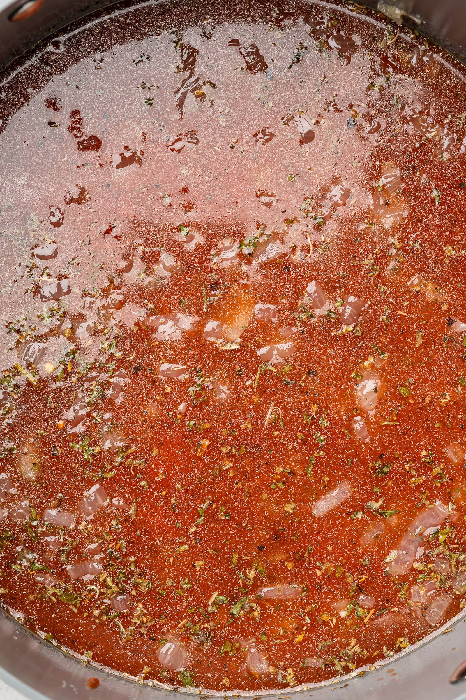 Seasoned tomato broth in large soup pot.