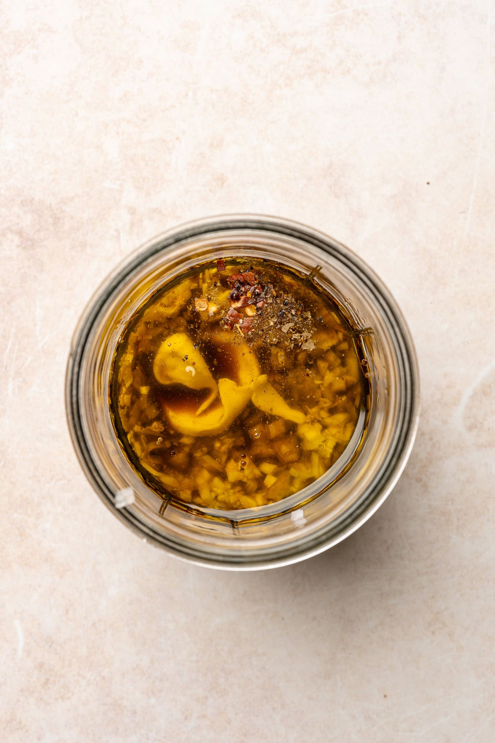 Unmixed balsamic dressing ingredients layered in a glass jar.