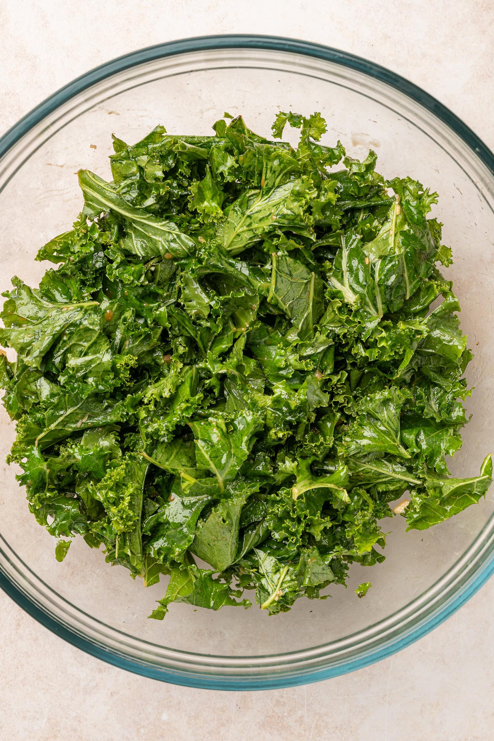 Massaged kale in a large glass jar.