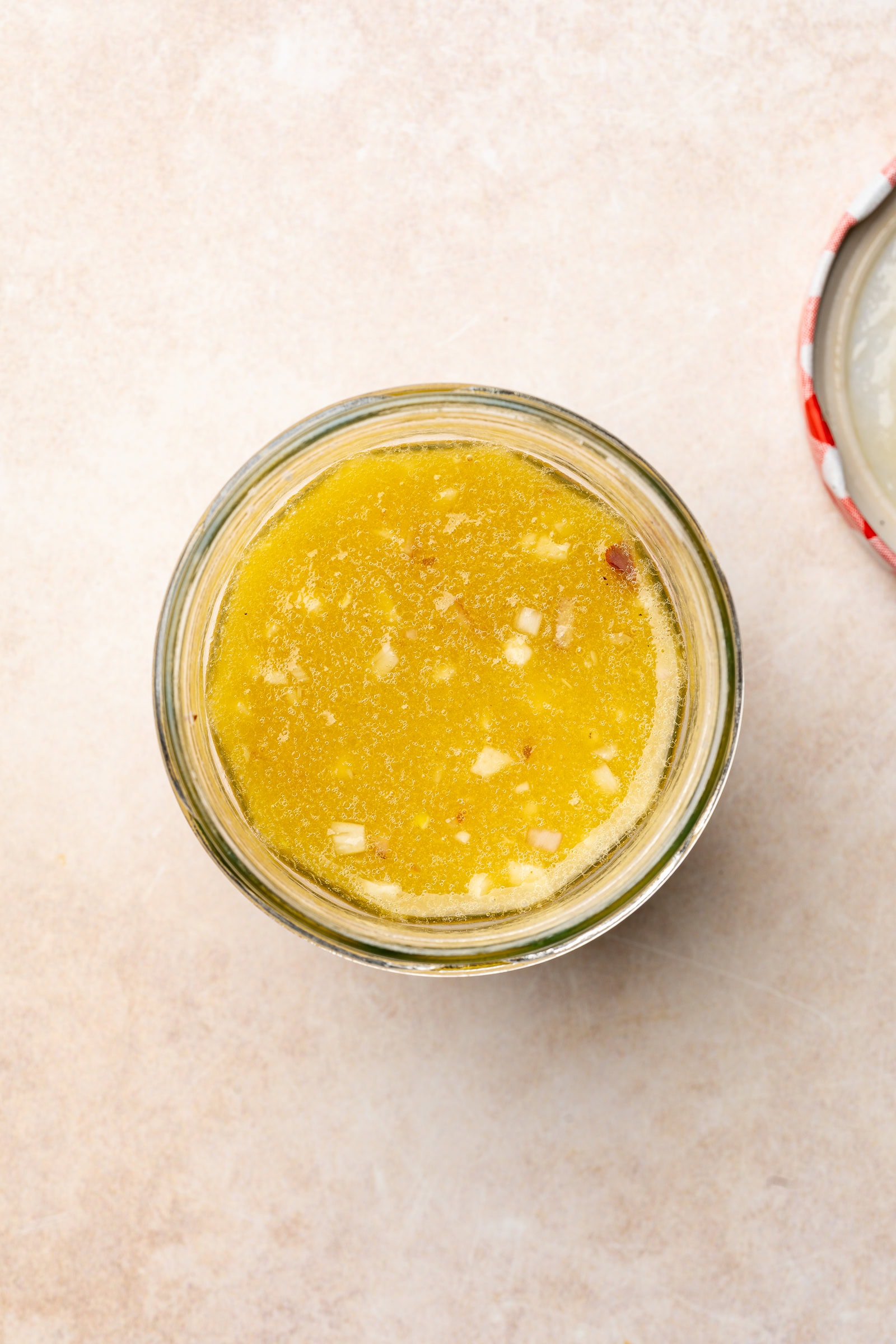 Apple cider vinaigrette in a jar after being shaken to be mixed.