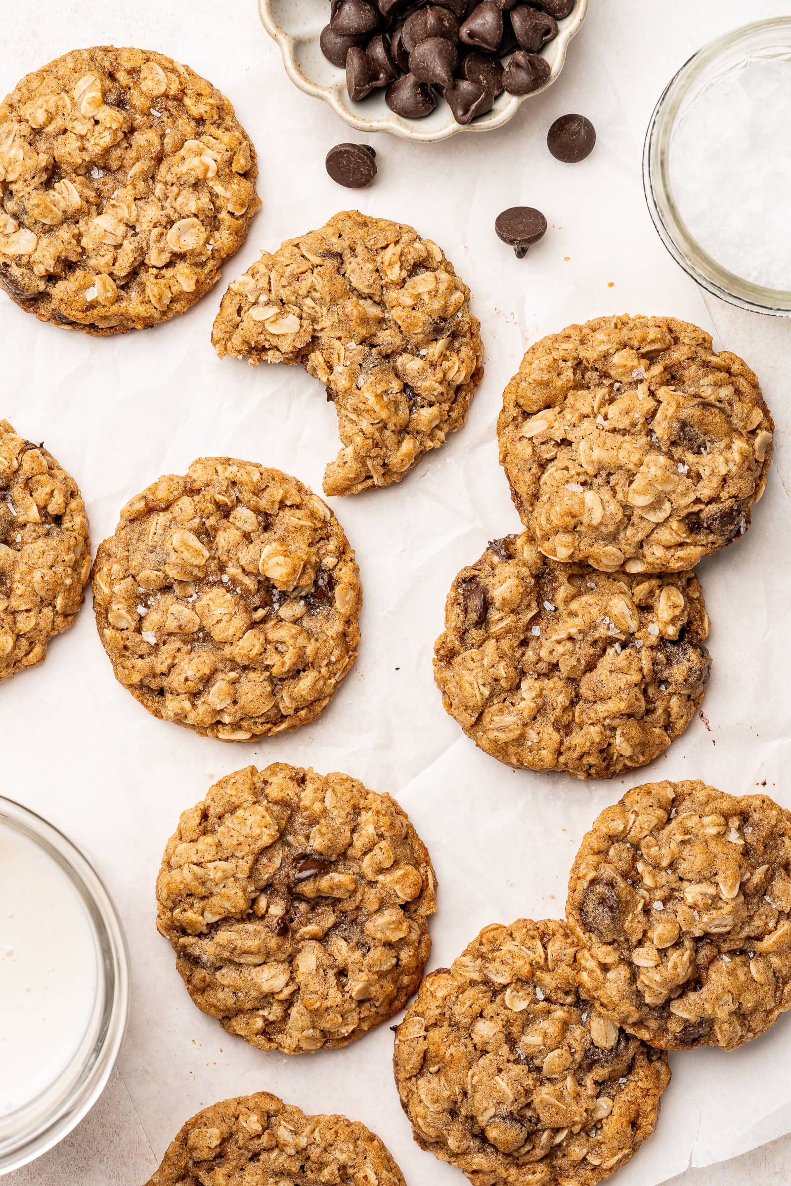 Vegan oatmeal chocolate chip cookies with flaky salt and served with milk.