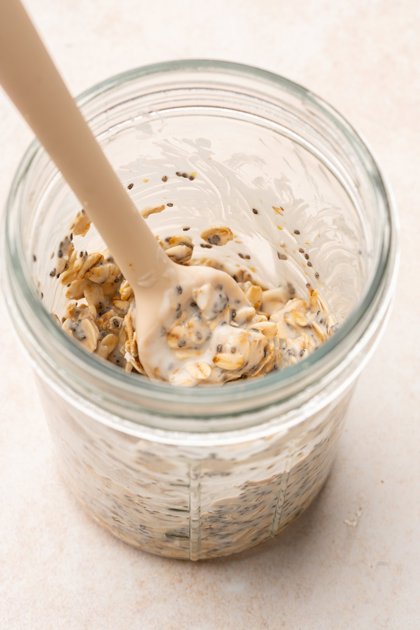 Overnight oat ingredients being mixed in a glass jar.
