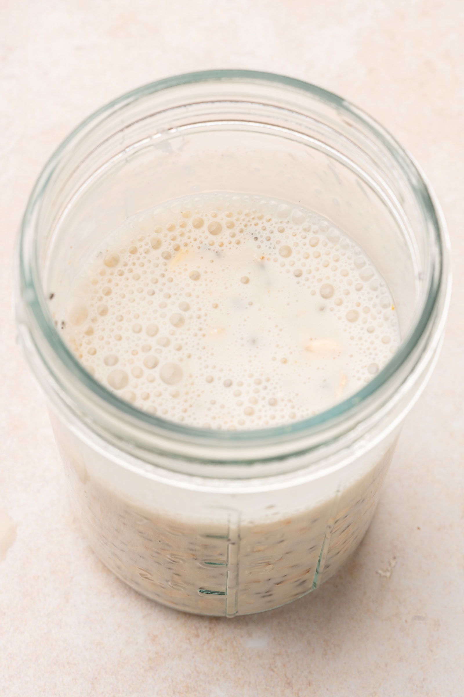 Overnight oat ingredients being mixed in a glass jar.