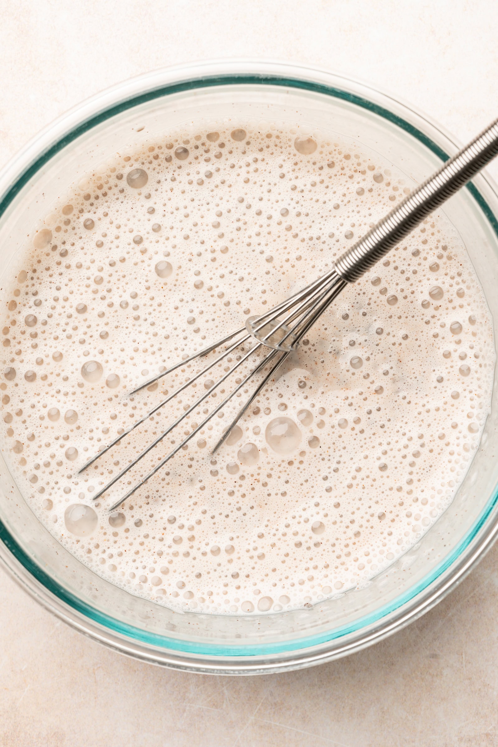 Oat milk chia pudding ingredients being whisked in bowl.