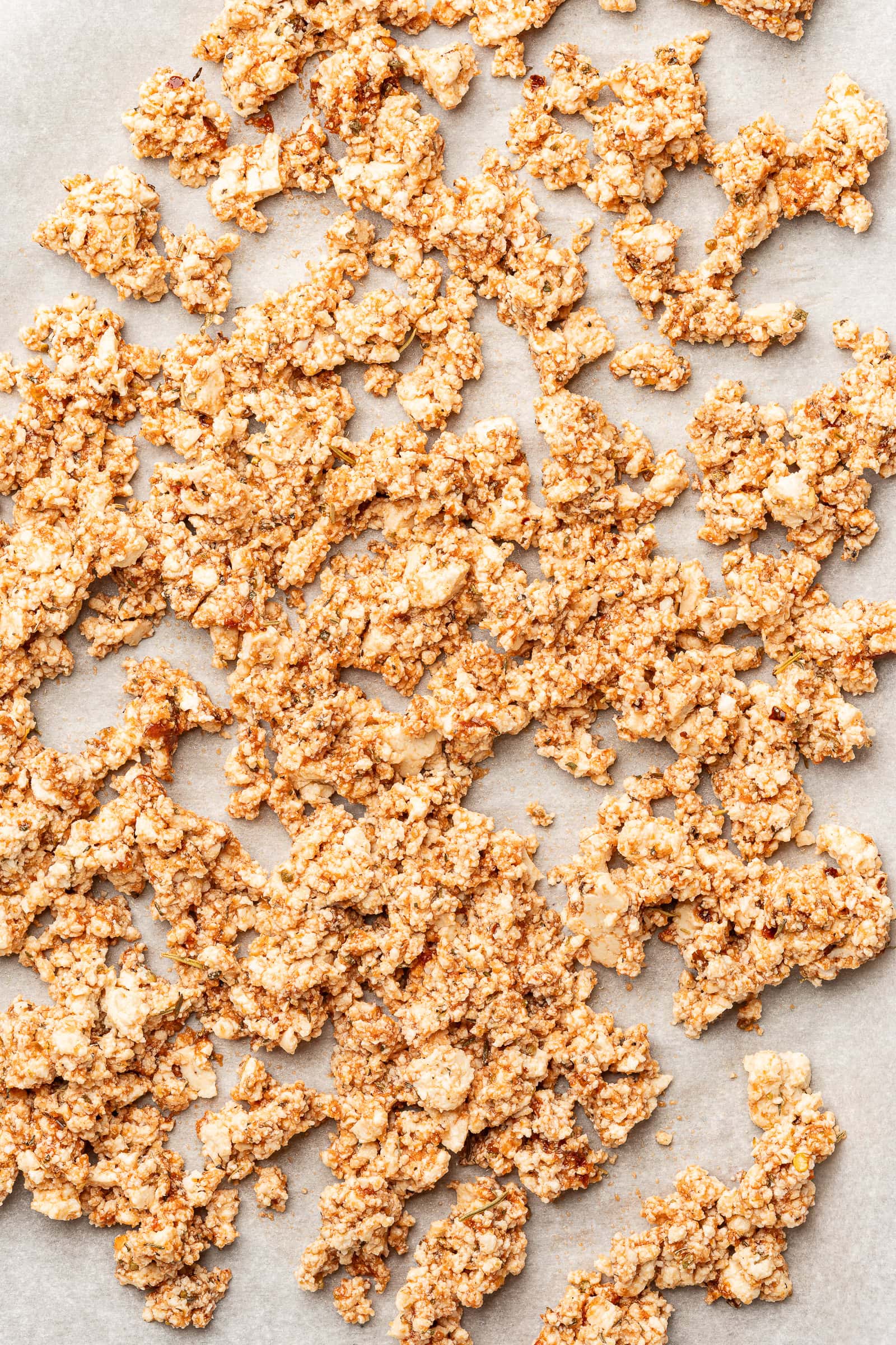 Seasoned tofu crumbles on baking sheet.