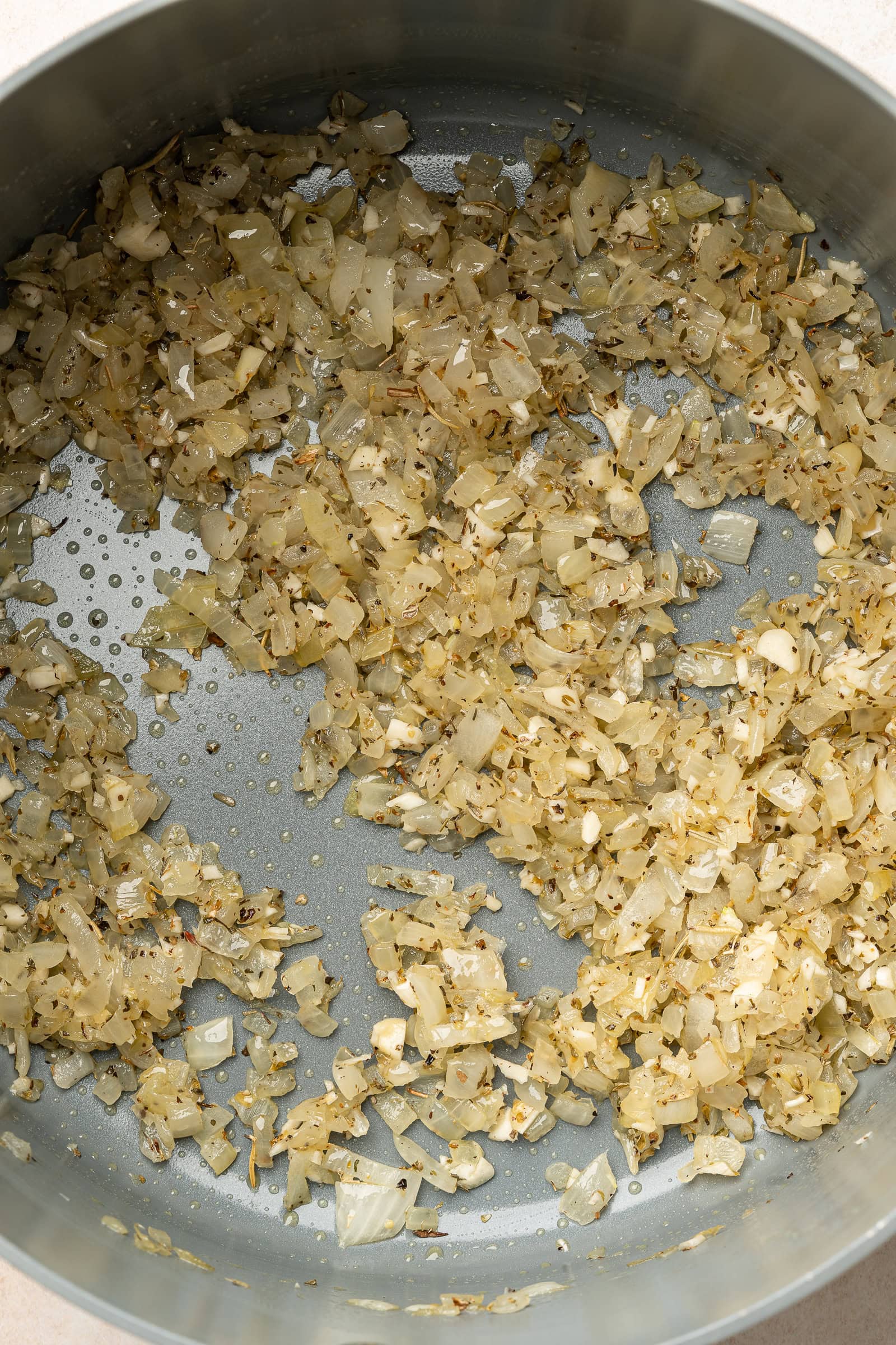 Italian seasonings added to sautéed onions in large pot.