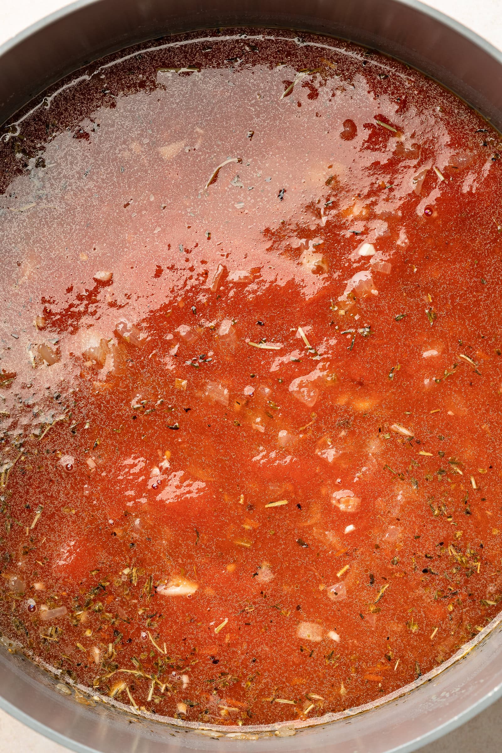 Tomatoes and broth mixed into sautéed onions.