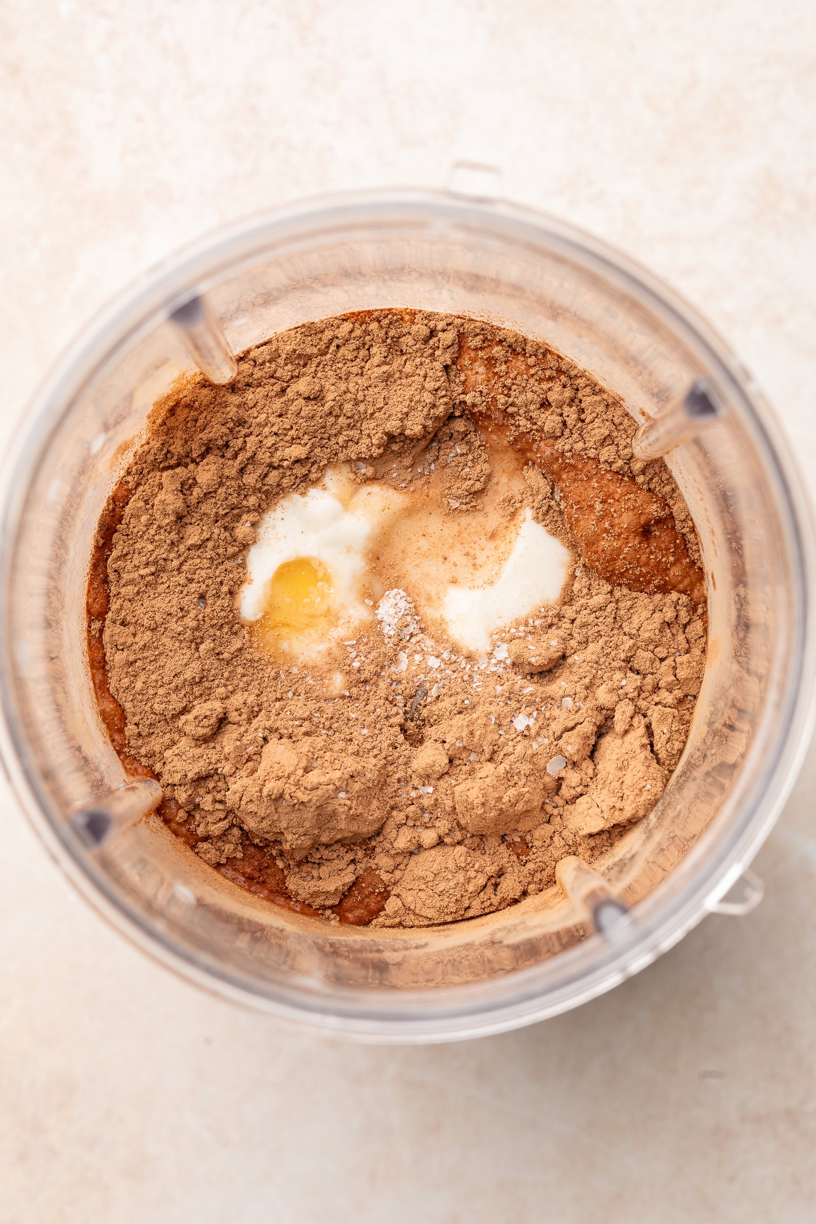 Banana, milk, cocoa powder, vegan yogurt, and salt in a nutribullet blender cup.