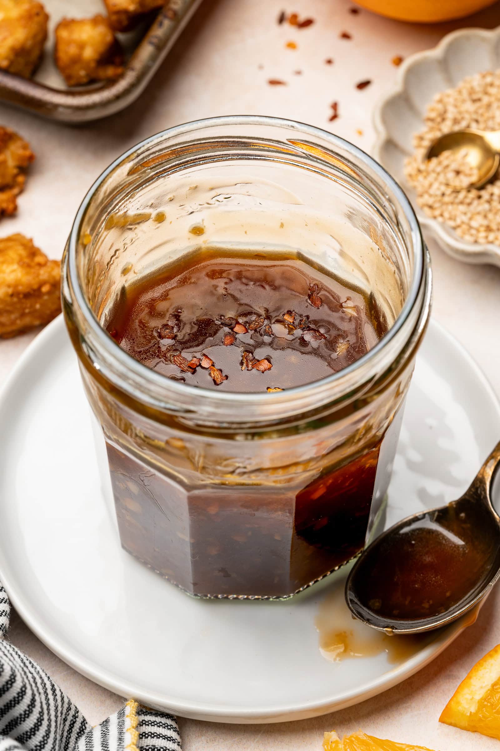 Vegan teriyaki sauce in a glass jar garnished with red pepper flakes.
