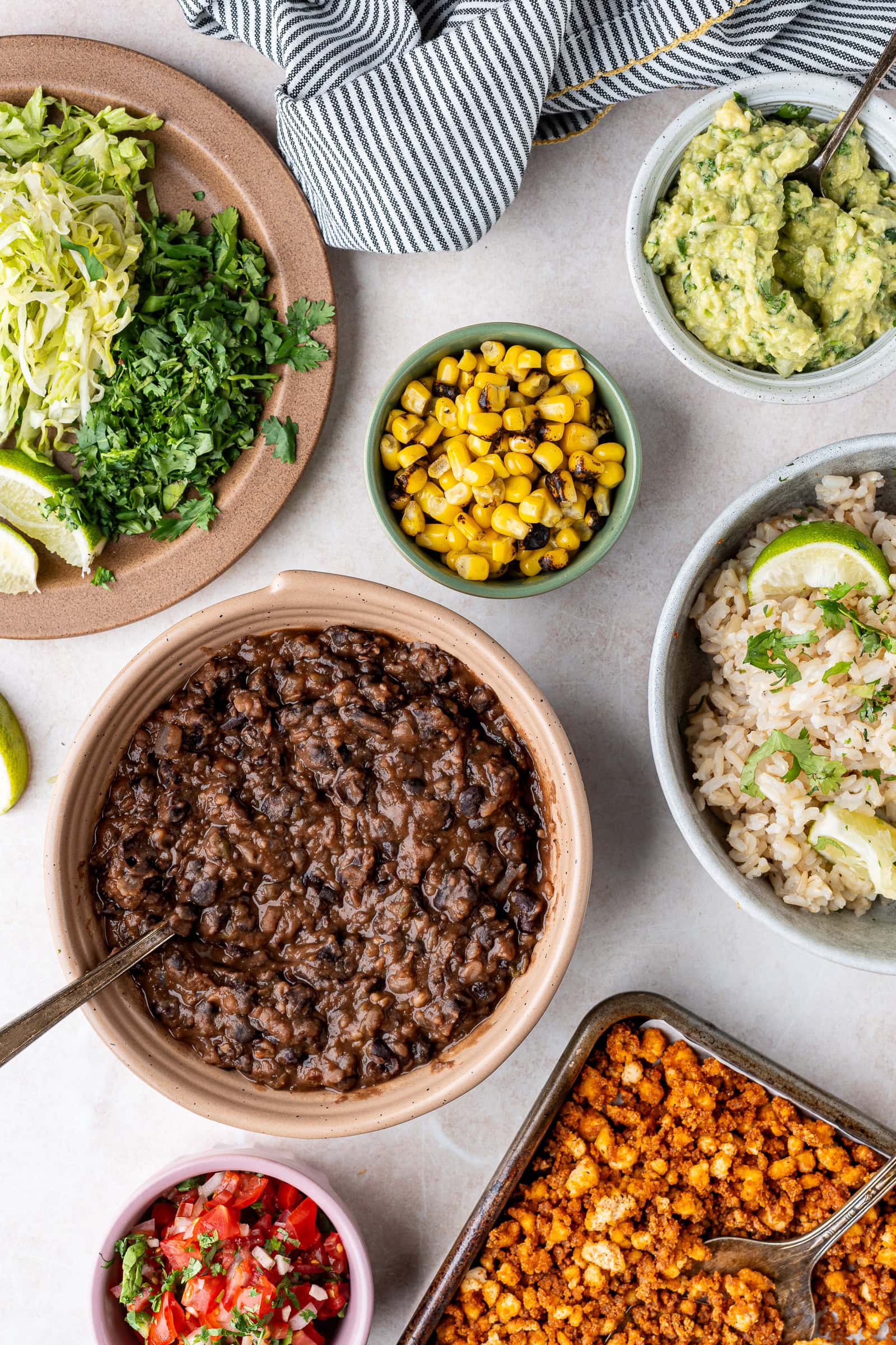 Ingredients for a vegan tofu burrito bowl arranged on a table.
