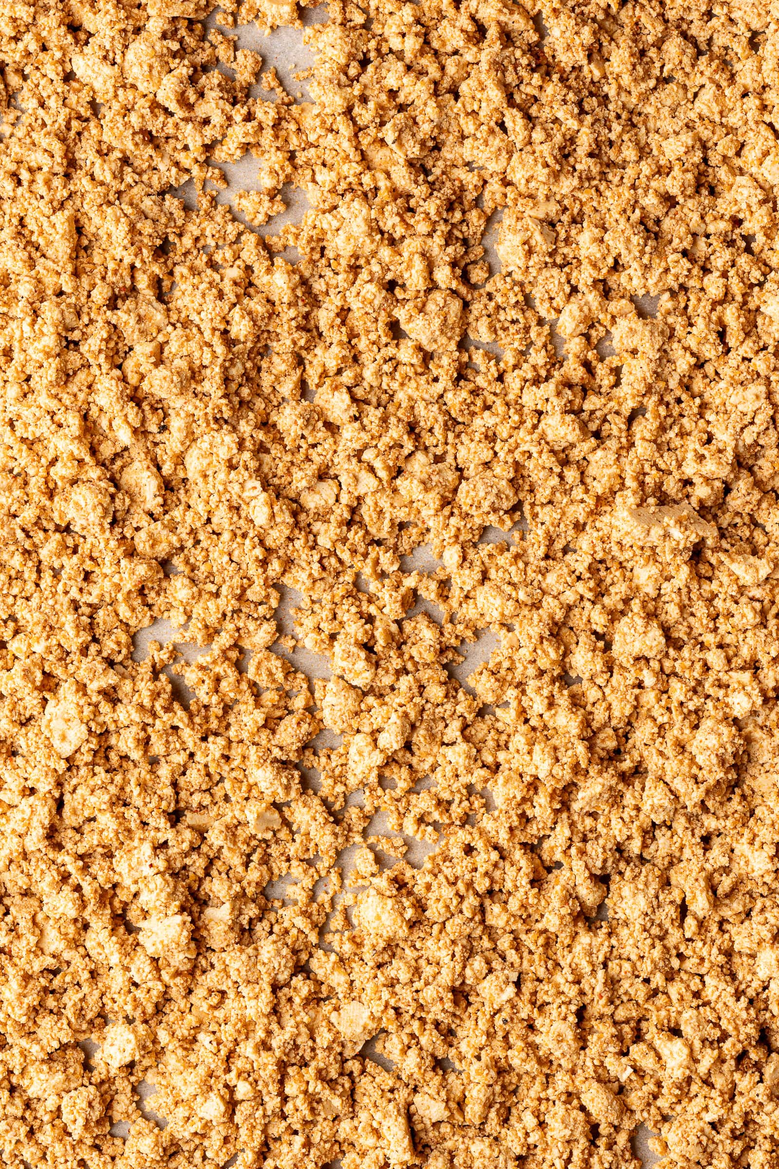 Seasoned tofu crumbles on baking sheet.