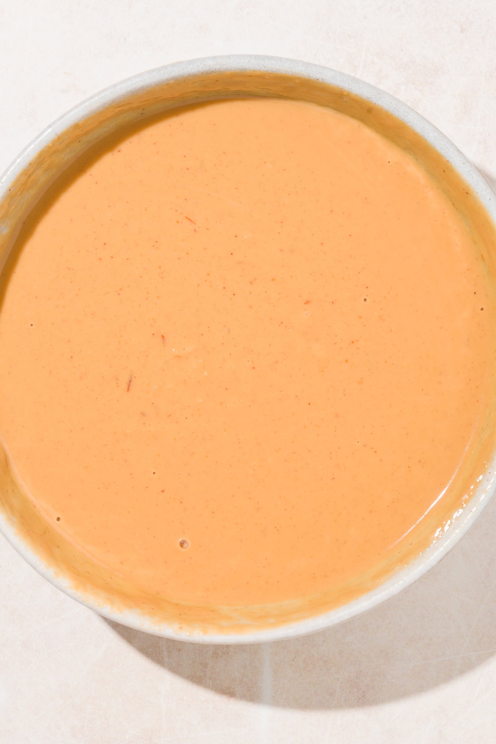Peanut sauce in a shallow bowl after being thinned out with water.