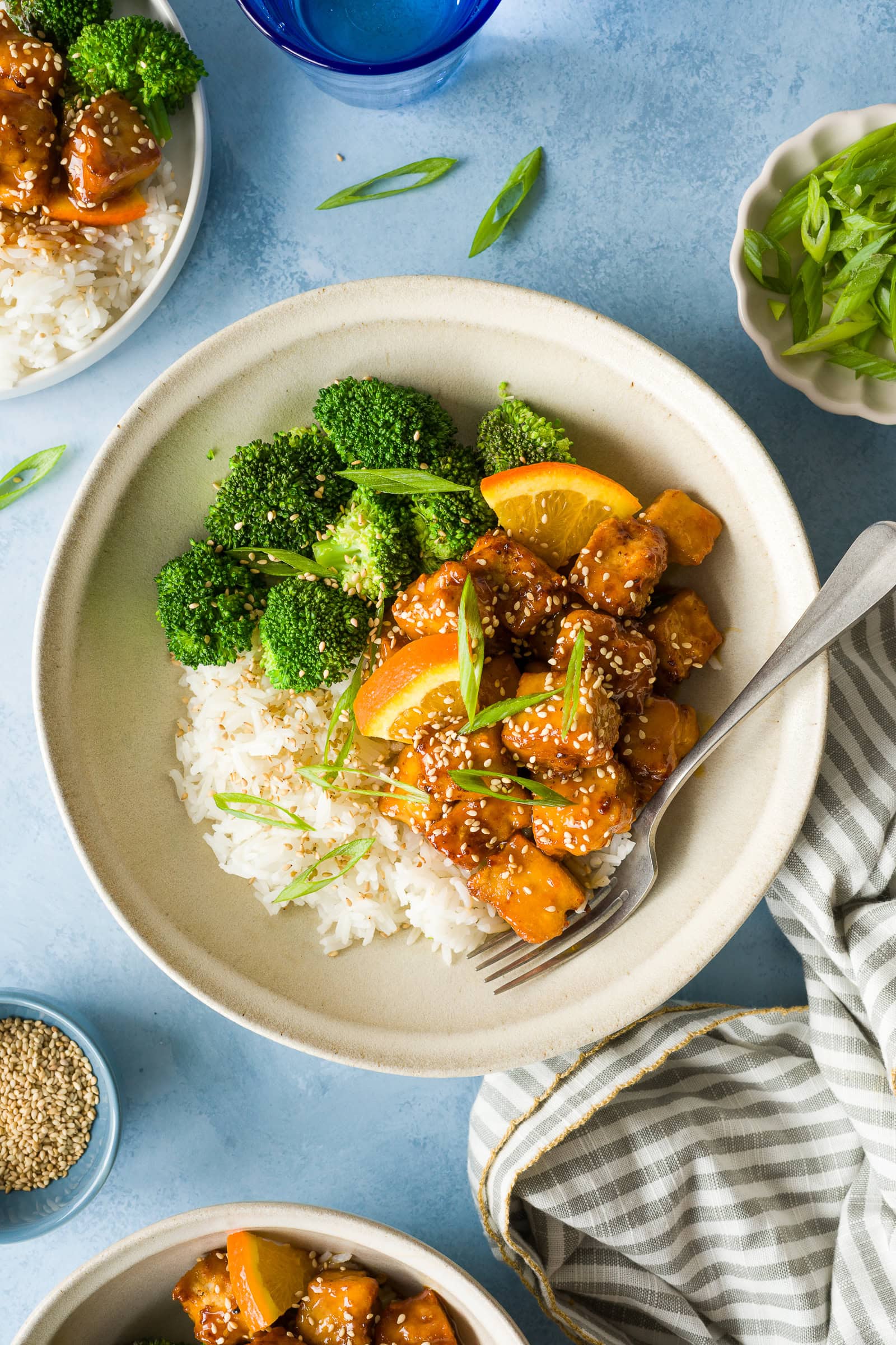 Crispy orange tofu served over rice with broccoli and green onions.