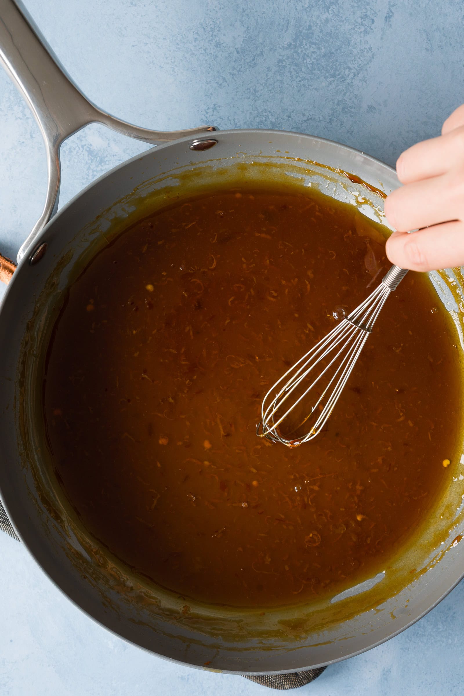 Orange sauce simmering in a skillet.