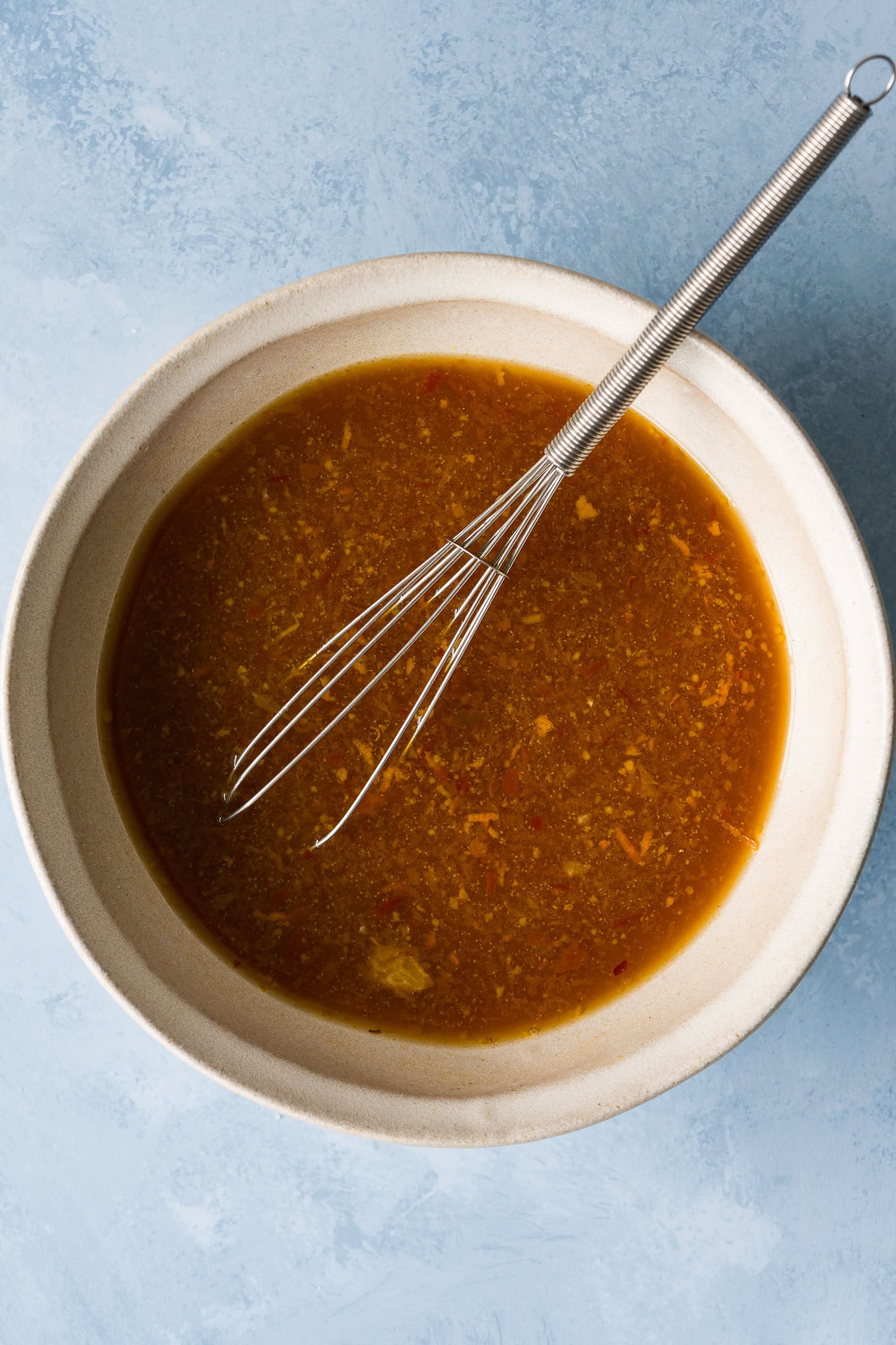 Orange sauce being whisked together.