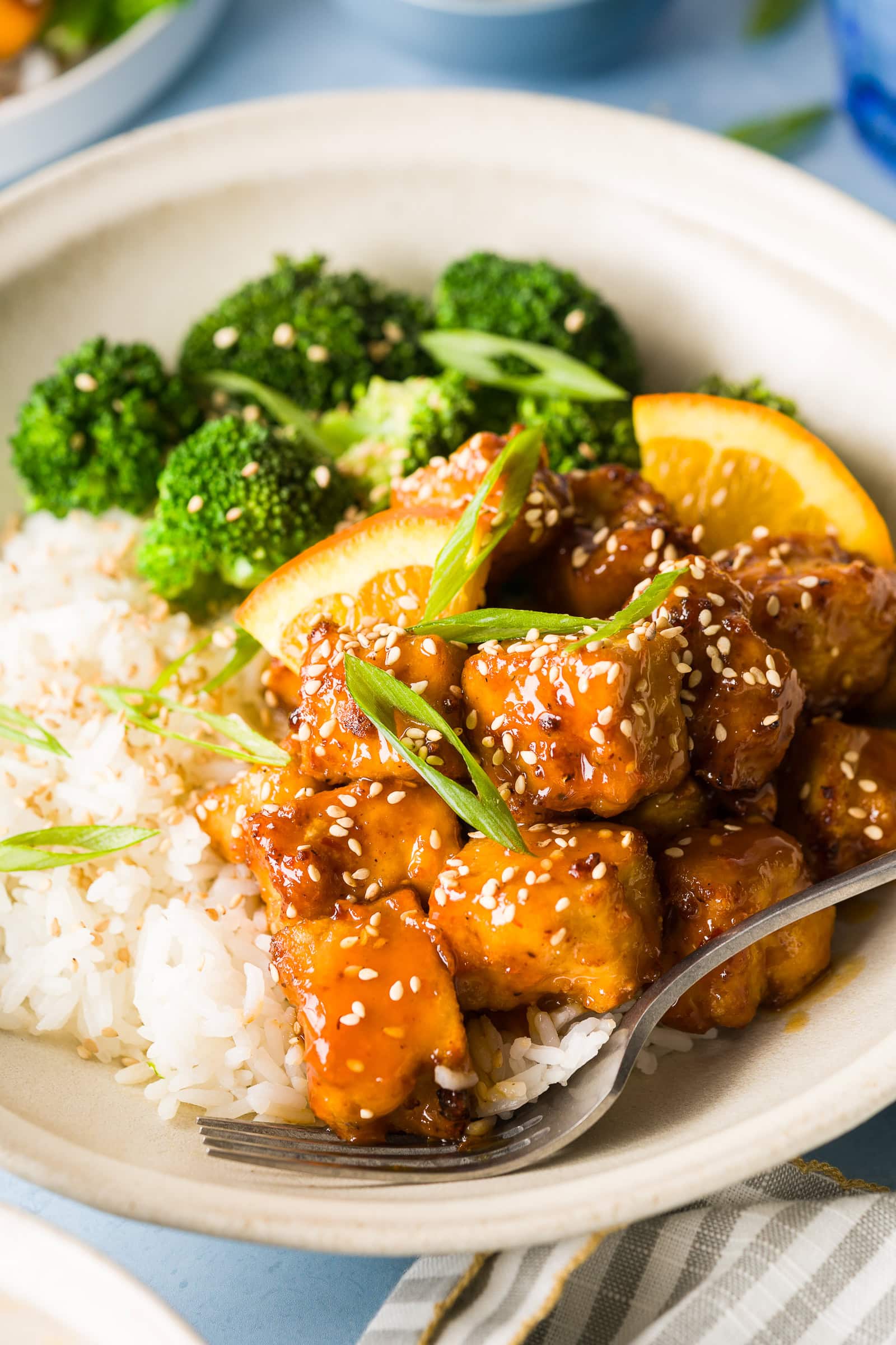 Close-up of crispy orange tofu tossed in orange sauce.