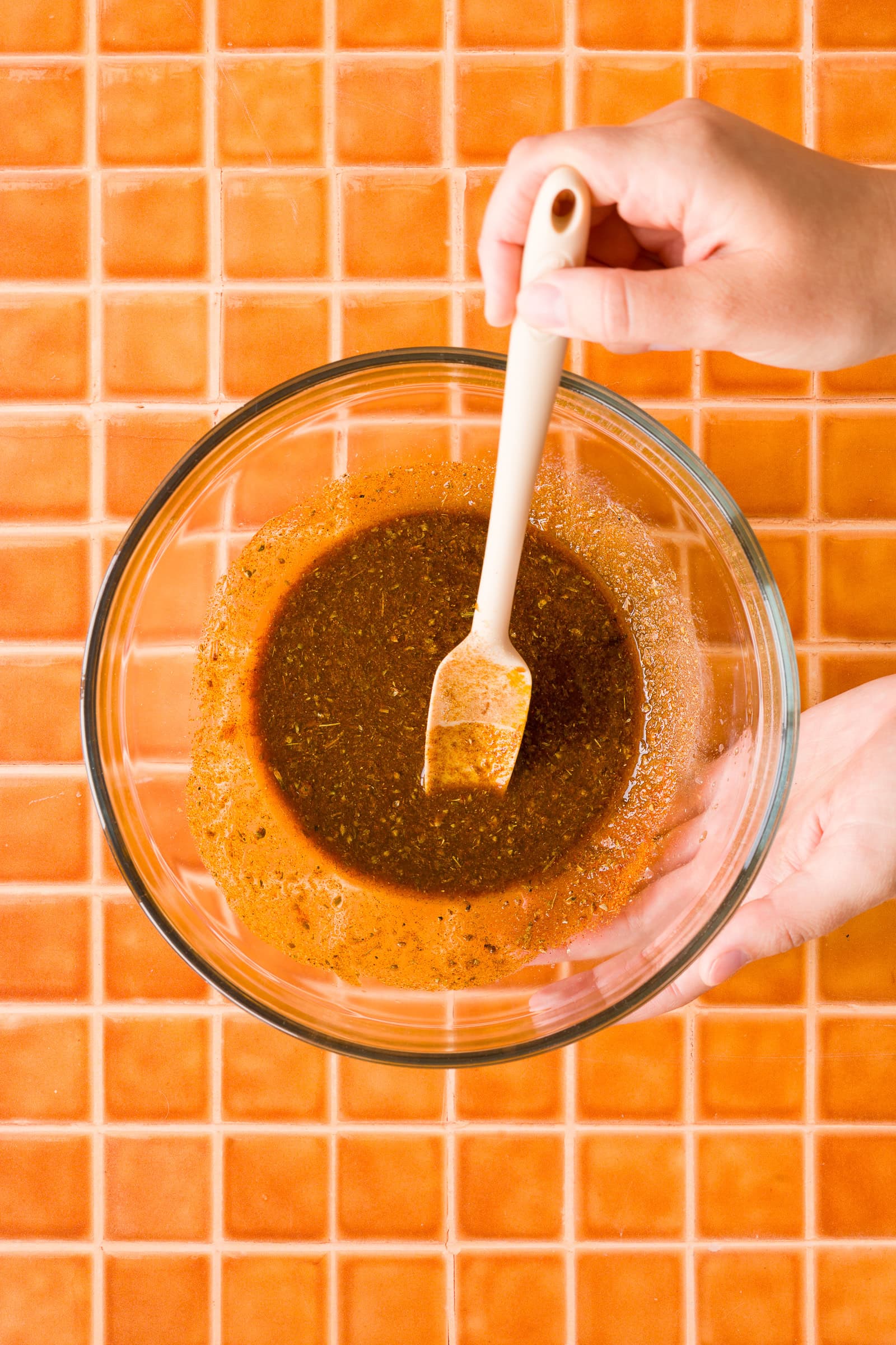 Whisking the shawarma marinade with olive oil, lemon juice, and spices.