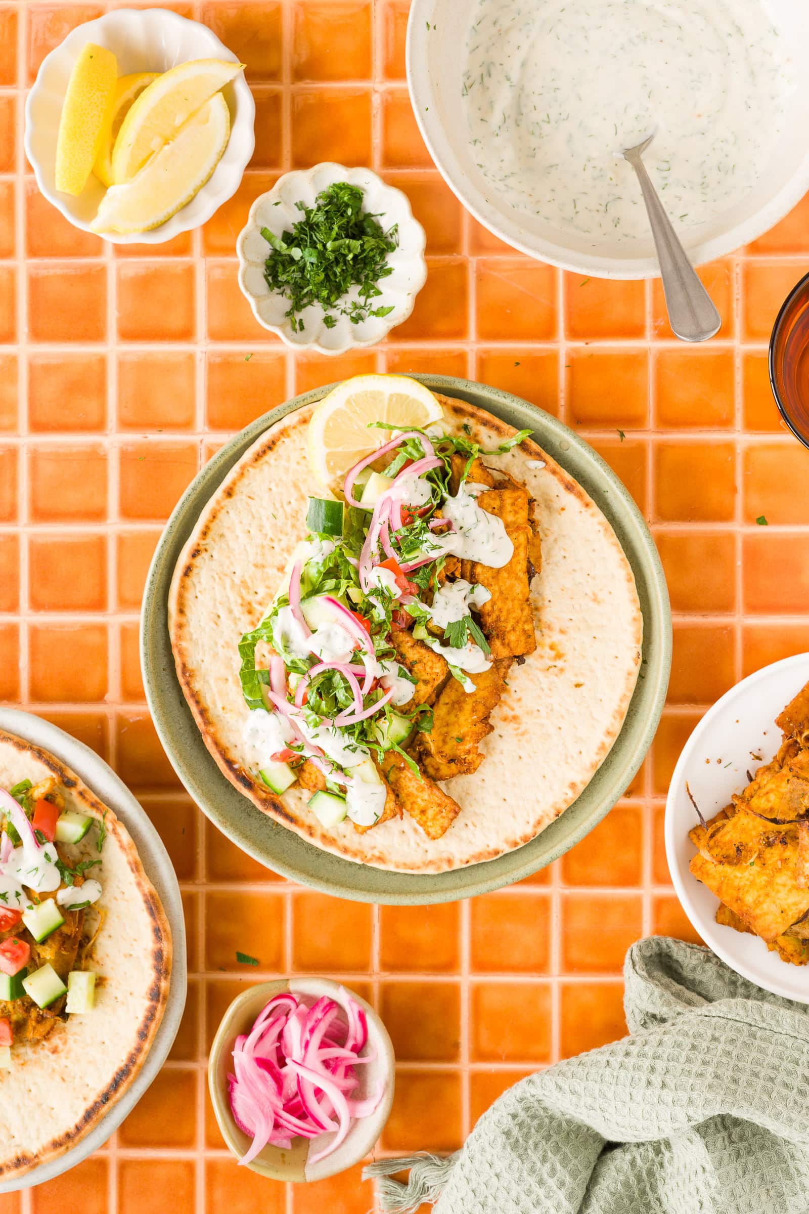 Shaved tofu shawarma served on flatbread with fresh vegetables and yogurt sauce.