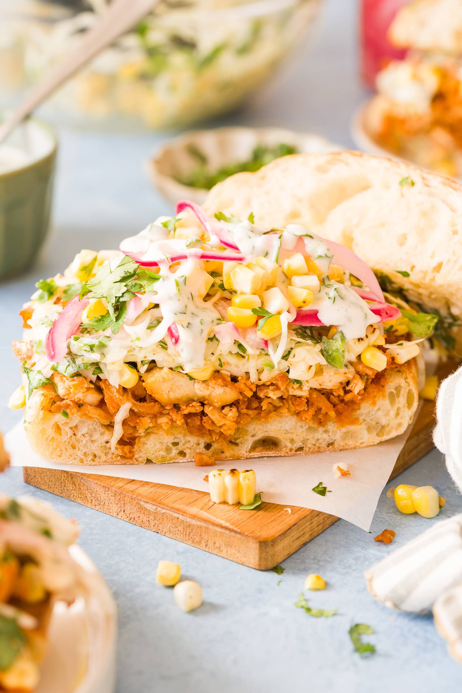 Open-faced BBQ tofu sandwich piled high with corn cabbage slaw, ranch, and pickled onions.