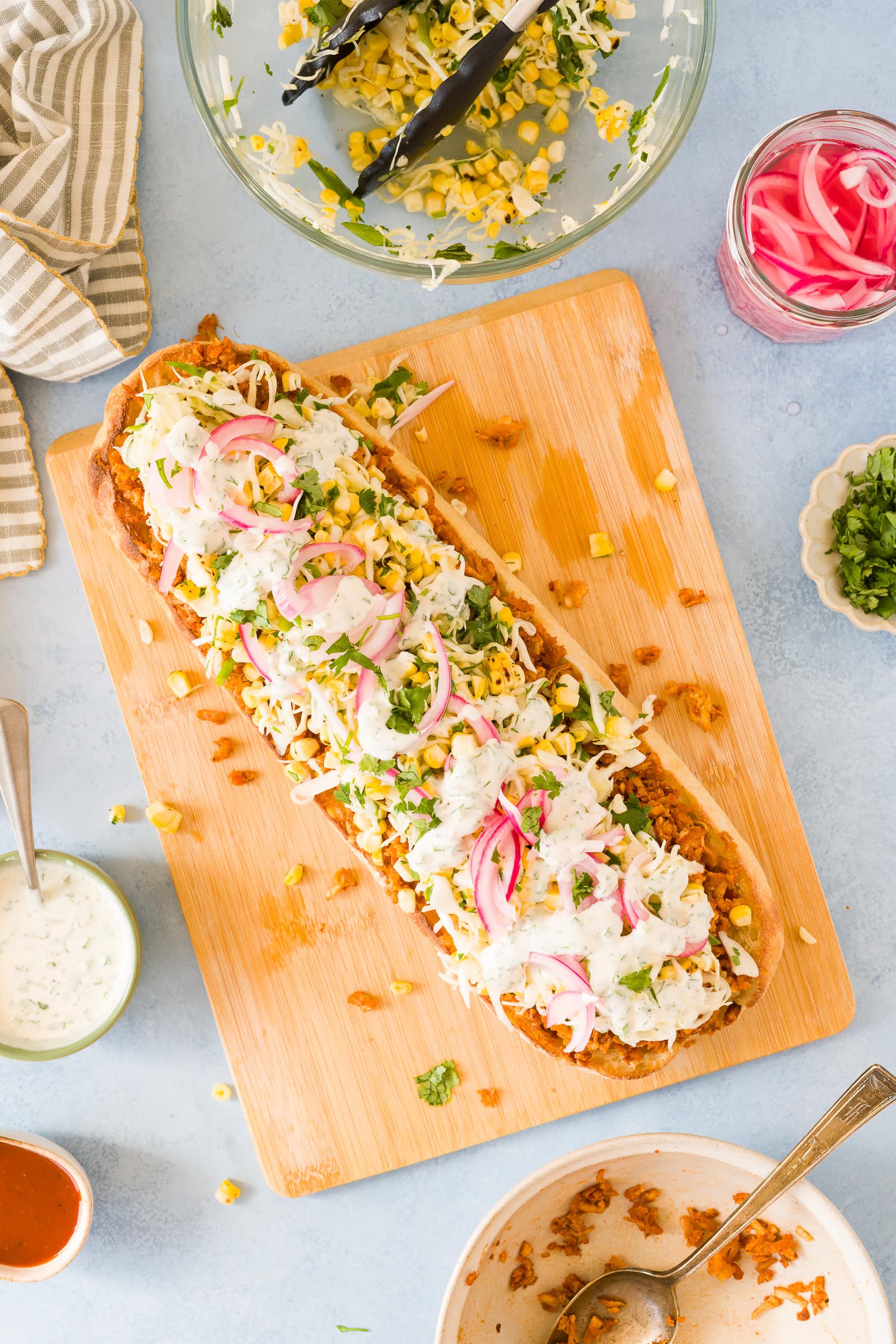 Long ciabatta loaf piled high on bbq tofu, corn cabbage slaw, and ranch drizzle.
