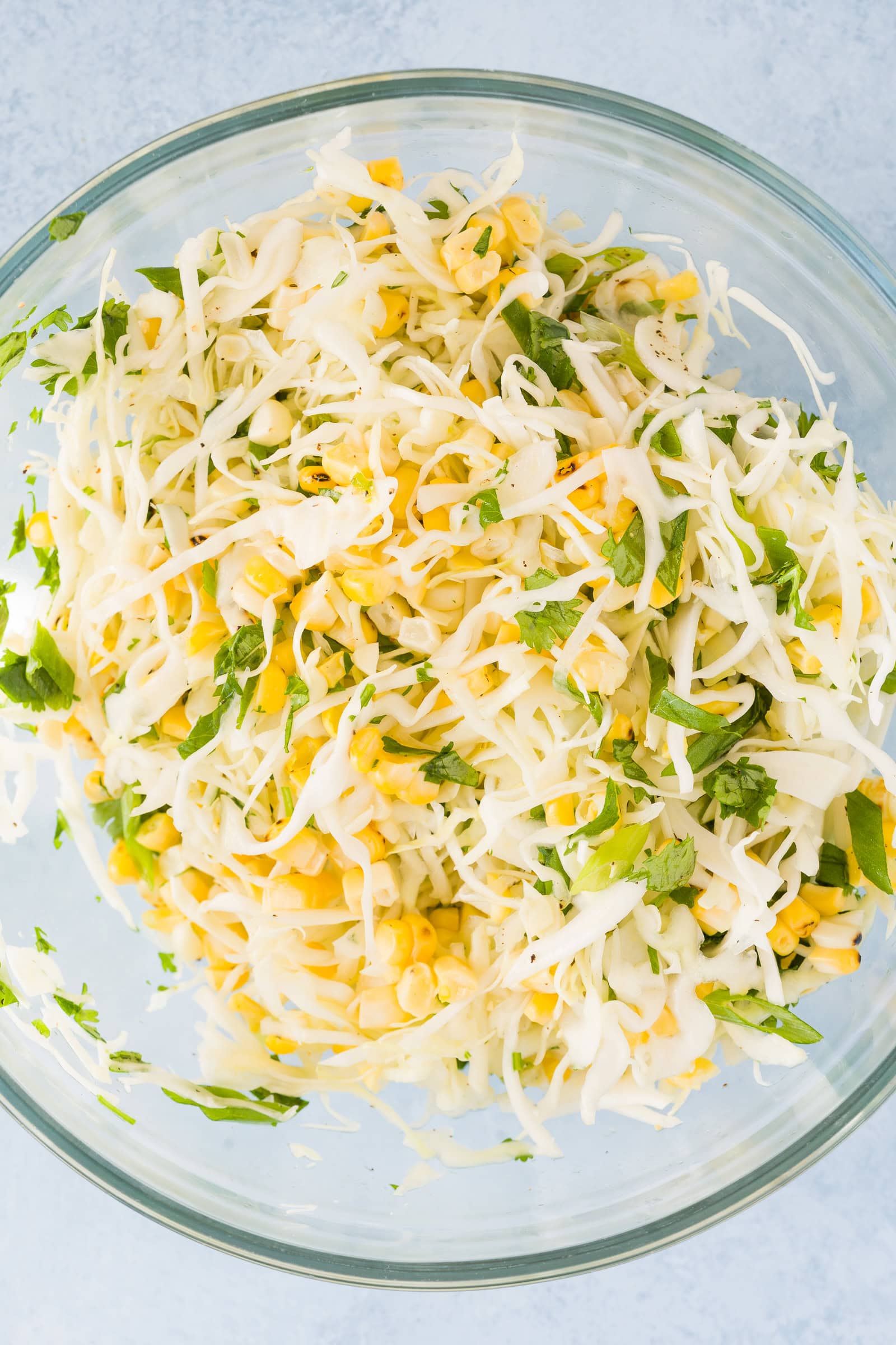 Mixed corn cabbage slaw in a glass bowl.