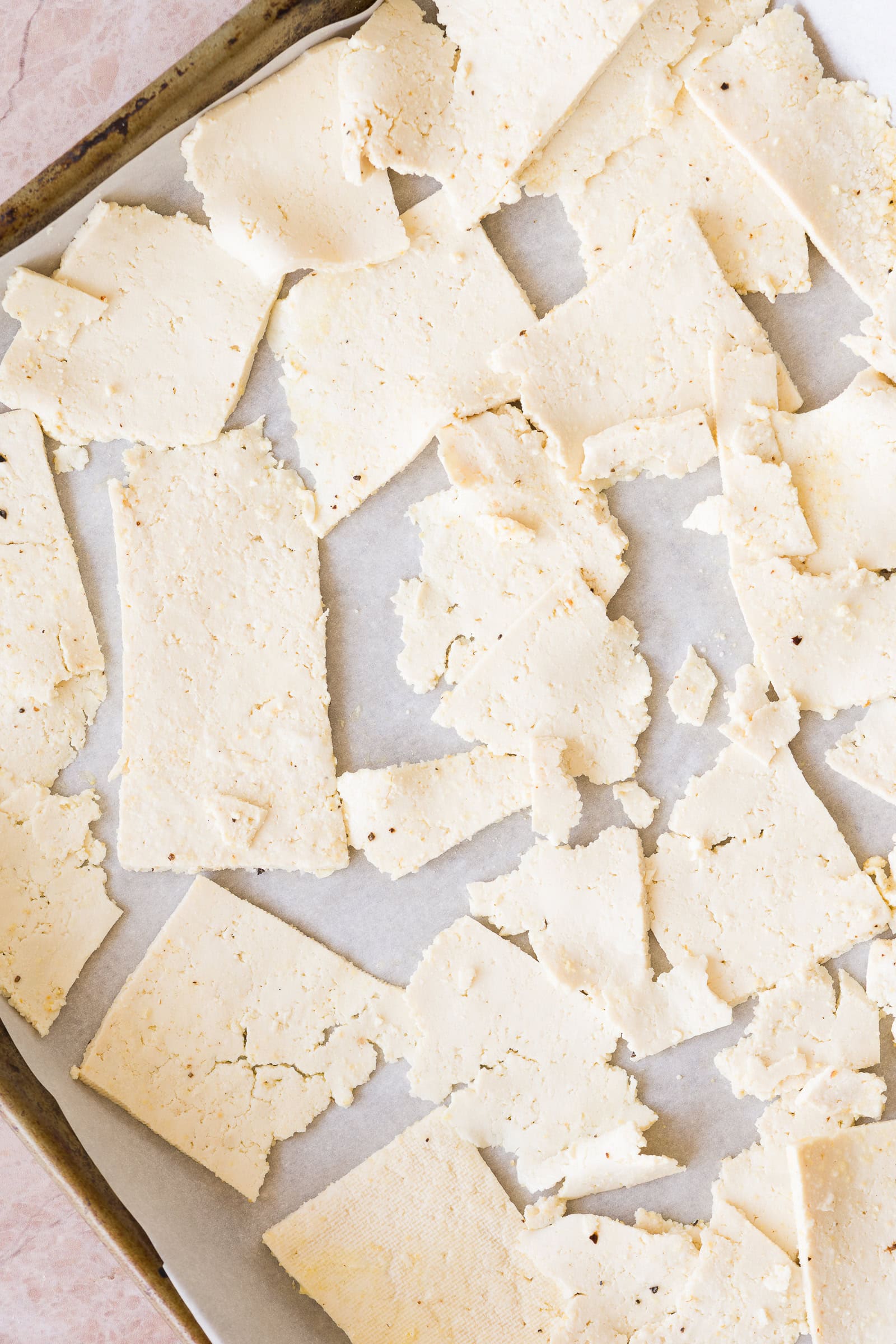 Thinly shaved tofu on a baking sheet.