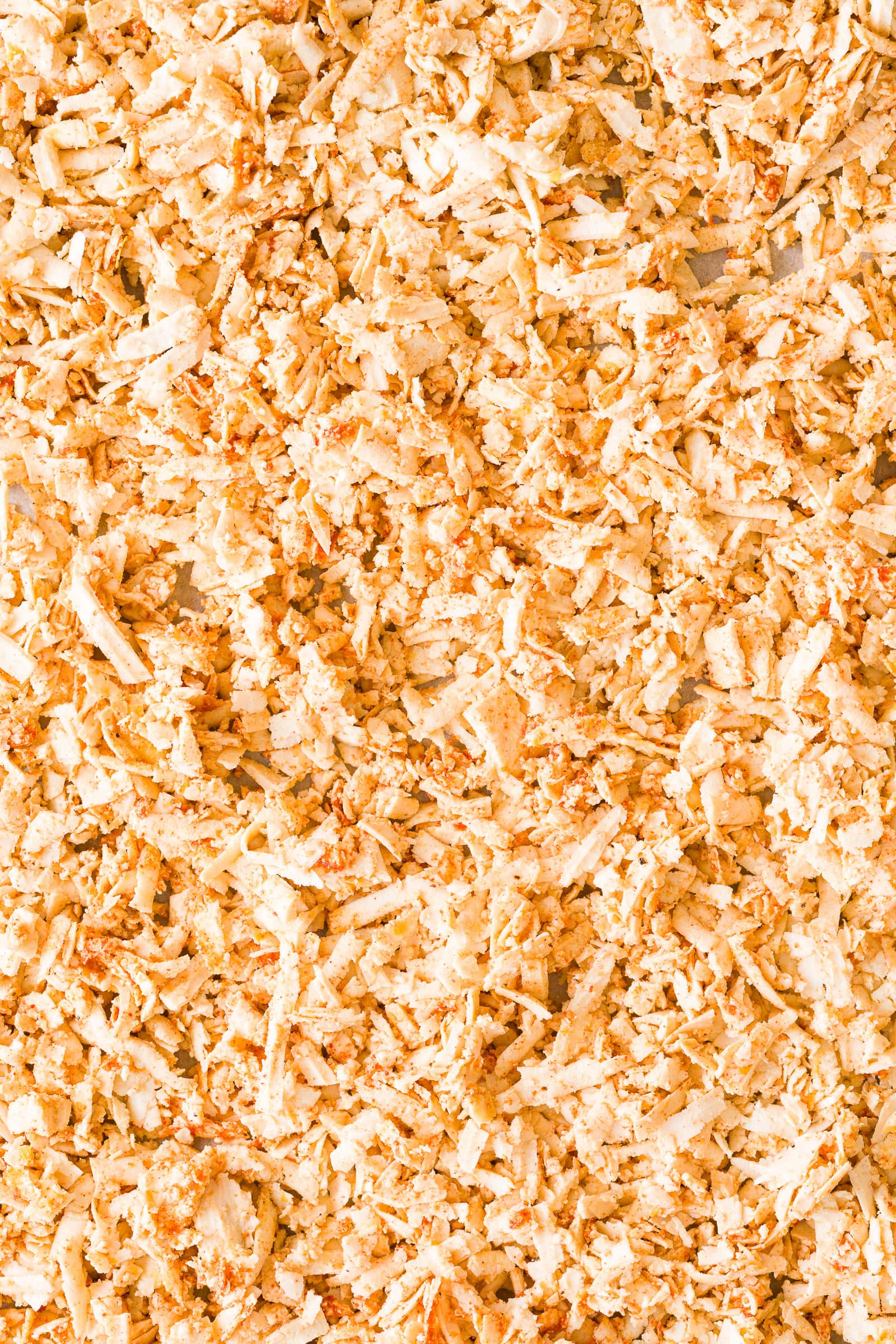 Unbaked and seasoned shredded tofu on baking sheet.